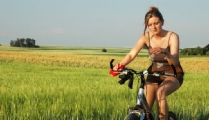 Žena jedoucí na kole kolem louky