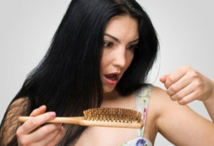 Žena vytahující vlasy z hřebenu 