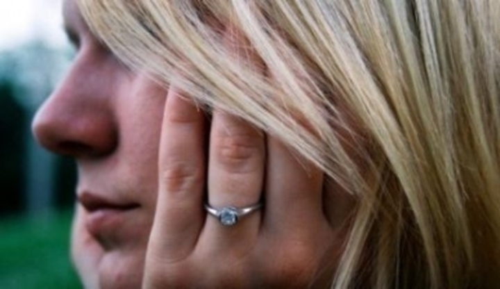 Žena s rukou na tváři a prstenem na prsteníčku 