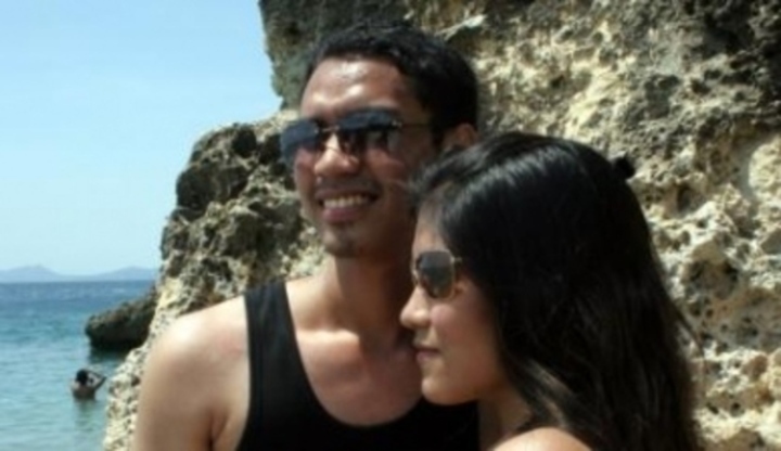 Dvojice se slunečními brýlemi stojící u skály, která zasahuje do moře