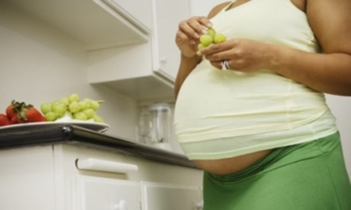Těhotná žena jí kuličky hroznového vína 