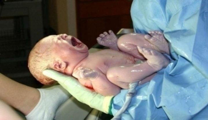 Křičící novorozenec v náruči lékaře 