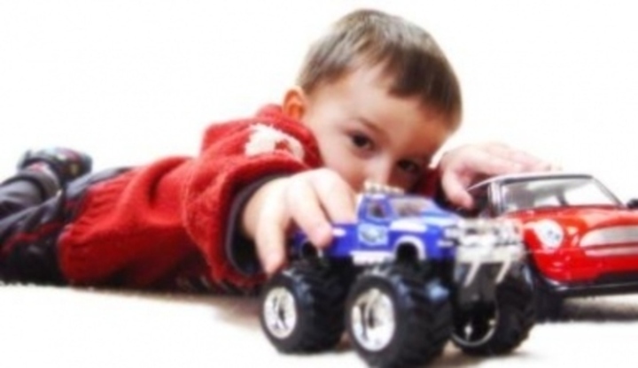 Dítě držící dvě barevné autíčka