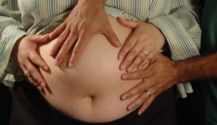 Ruce položené na těhotenském břichu 
